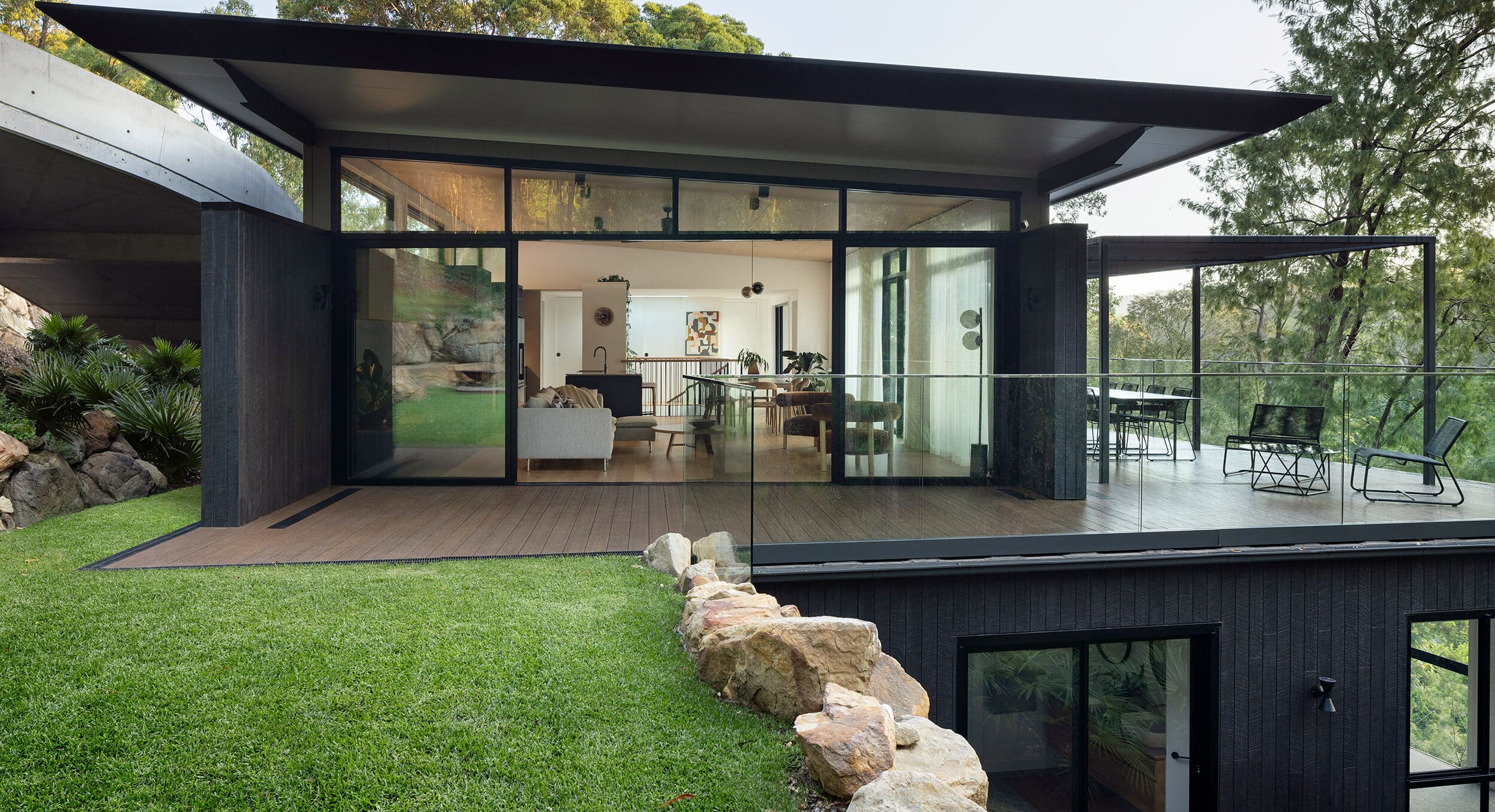 a black modern house with a deck