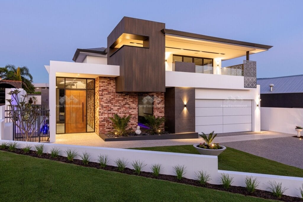 Luxurious modern home at dusk showcasing a striking blend of composite cladding, elegant brickwork, and contemporary architecture with landscaped garden