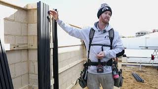 Skilled carpenter installing modern vertical castellation cladding on a commercial property, showcasing precision and craftsmanship