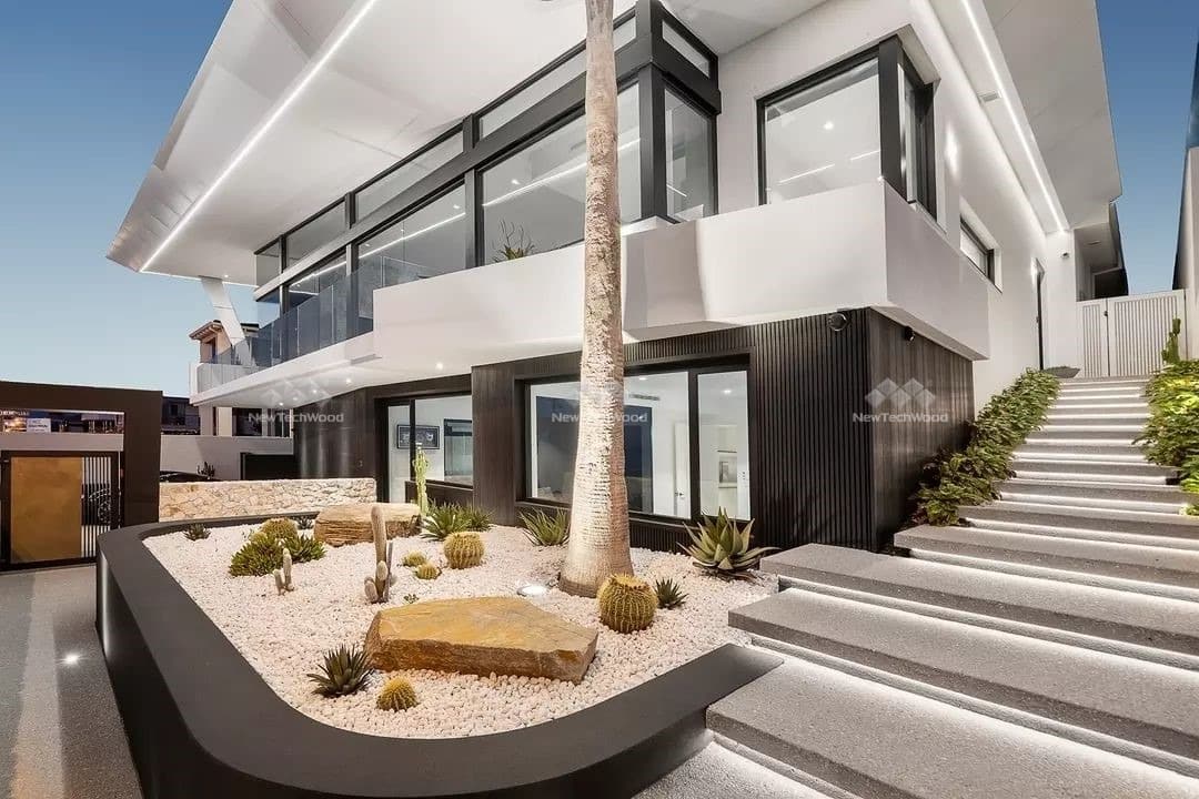 Luxurious multi-level architectural home featuring striking white facades and dynamic angles, complemented by a desert-inspired garden with cacti and succulents