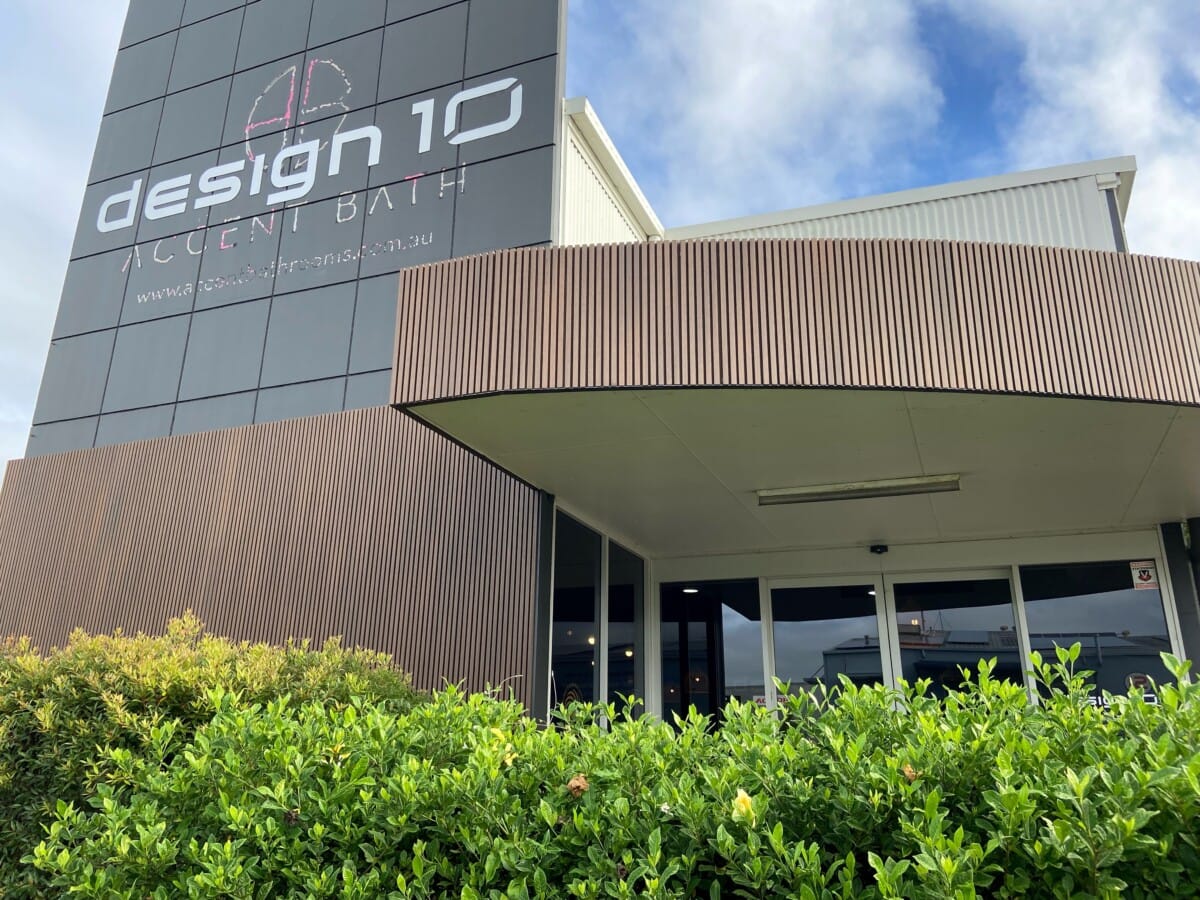 Design 10 building exterior with wooden clad facade and lush greenery.