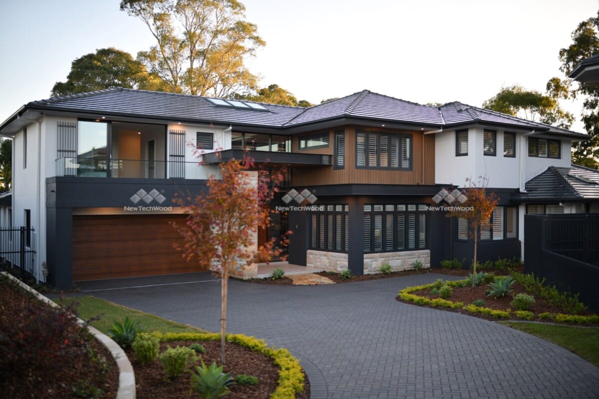 Luxury modern home with NewTechWood accents and landscaped driveway.