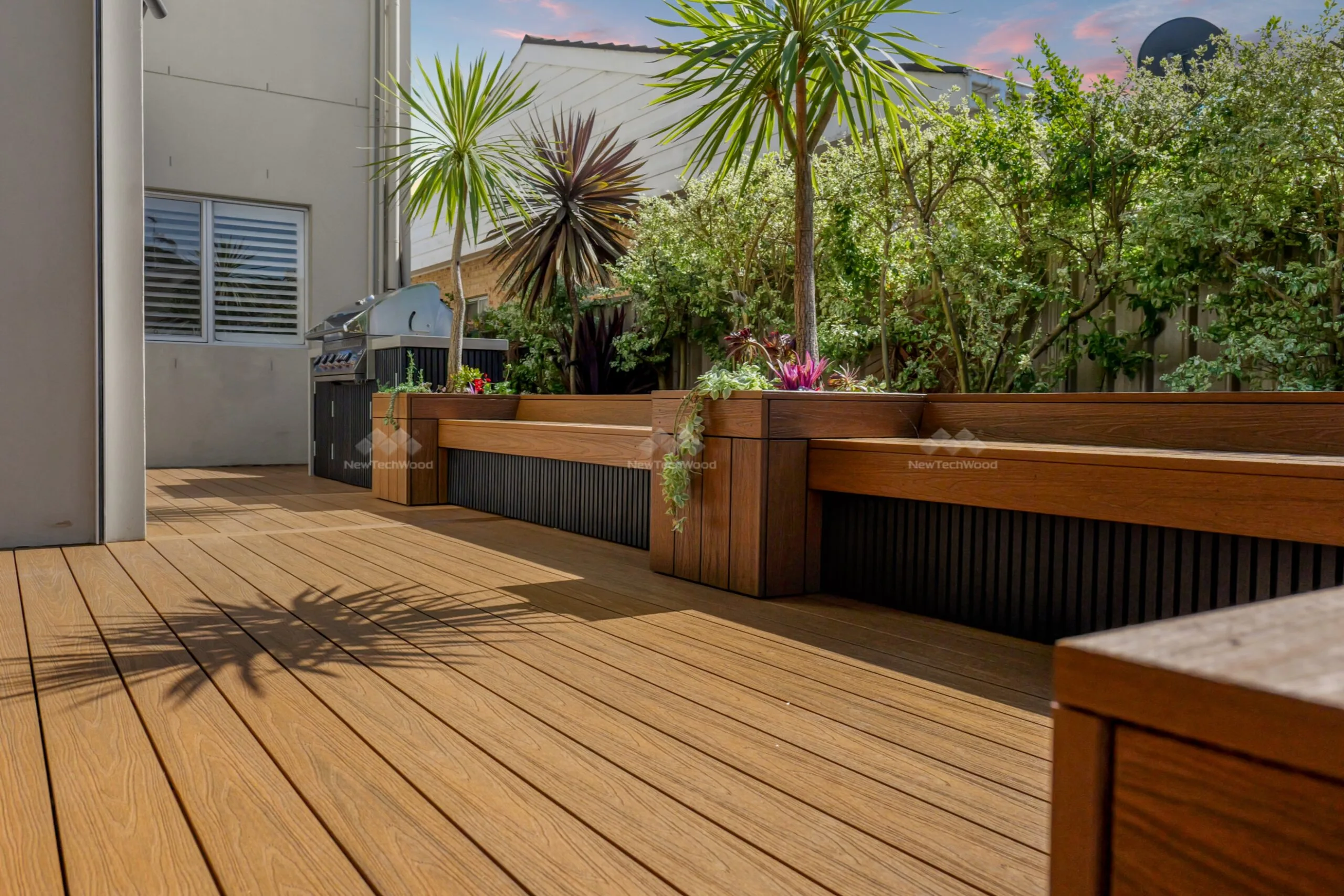A stunning poolside area with NewTechWood composite decking, offering a durable and stylish outdoor flooring solution.